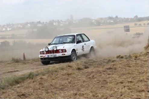 BMW E30 318is Rallyefahrzeug in der Kurve mit Staubfahne