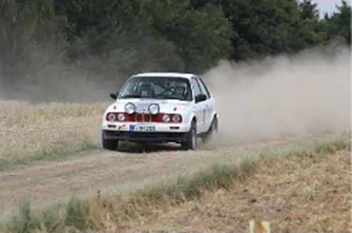 Weißer BMW E30 Rallye 318is Cup mit Staubwolke